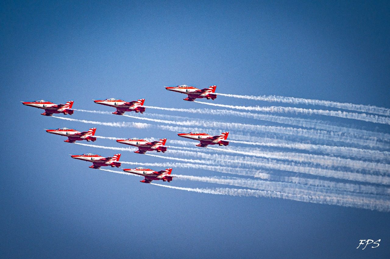 The nine-aircraft diamond with white trails